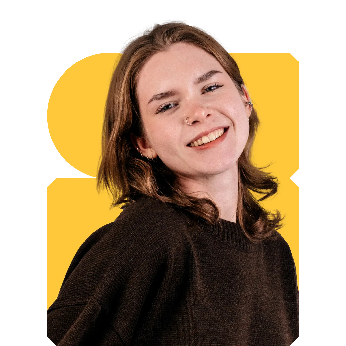 Smiling young adult with shoulder‑length brown hair, nose ring and dark jumper on a yellow graphic background.