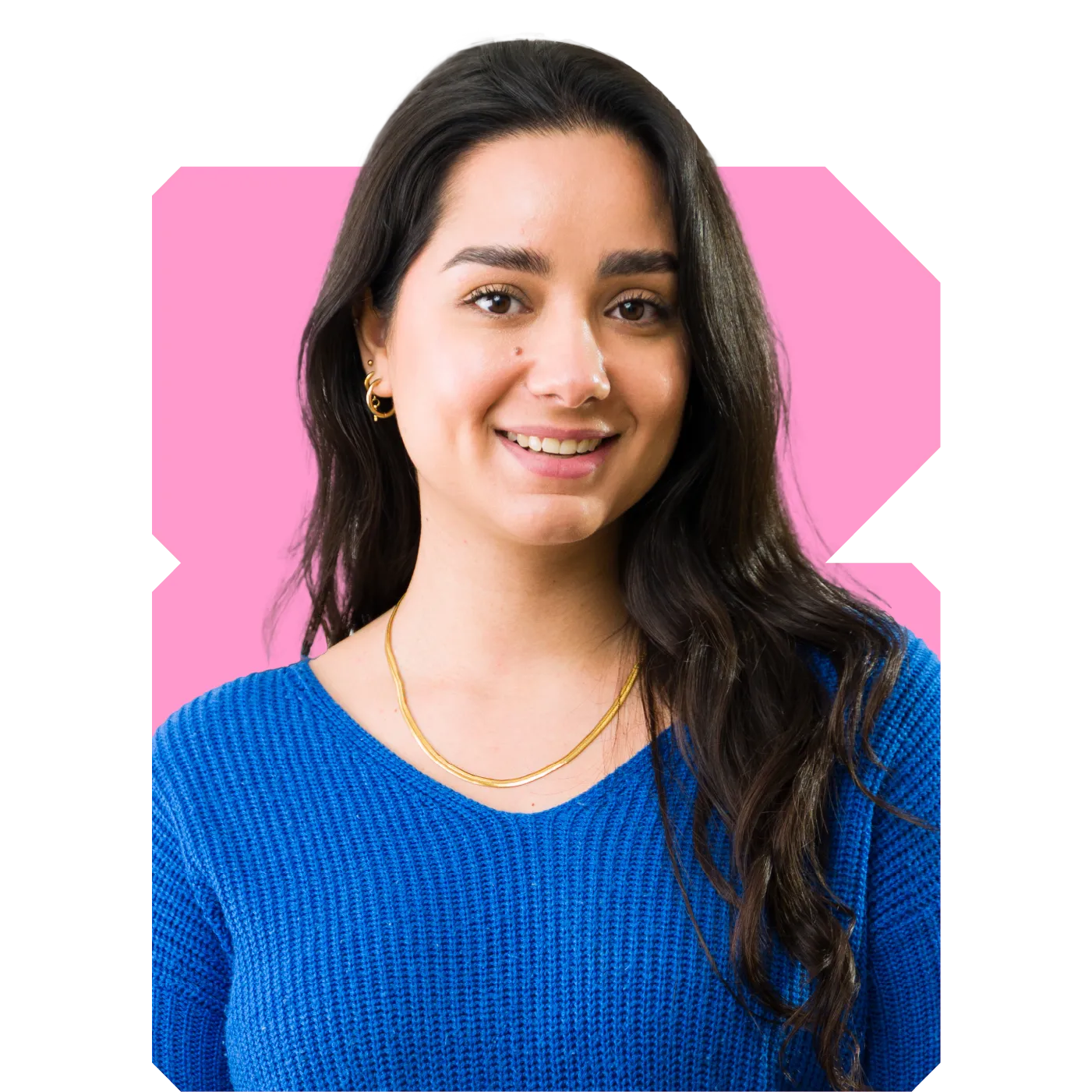 Smiling woman with long dark hair, blue knit sweater and gold necklace against pink background