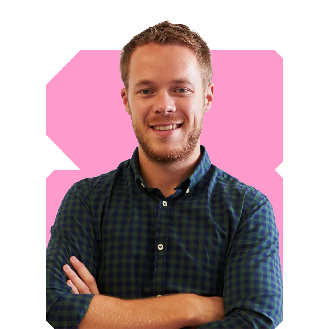 Smiling young man with folded arms wearing a green checked shirt against a pink background